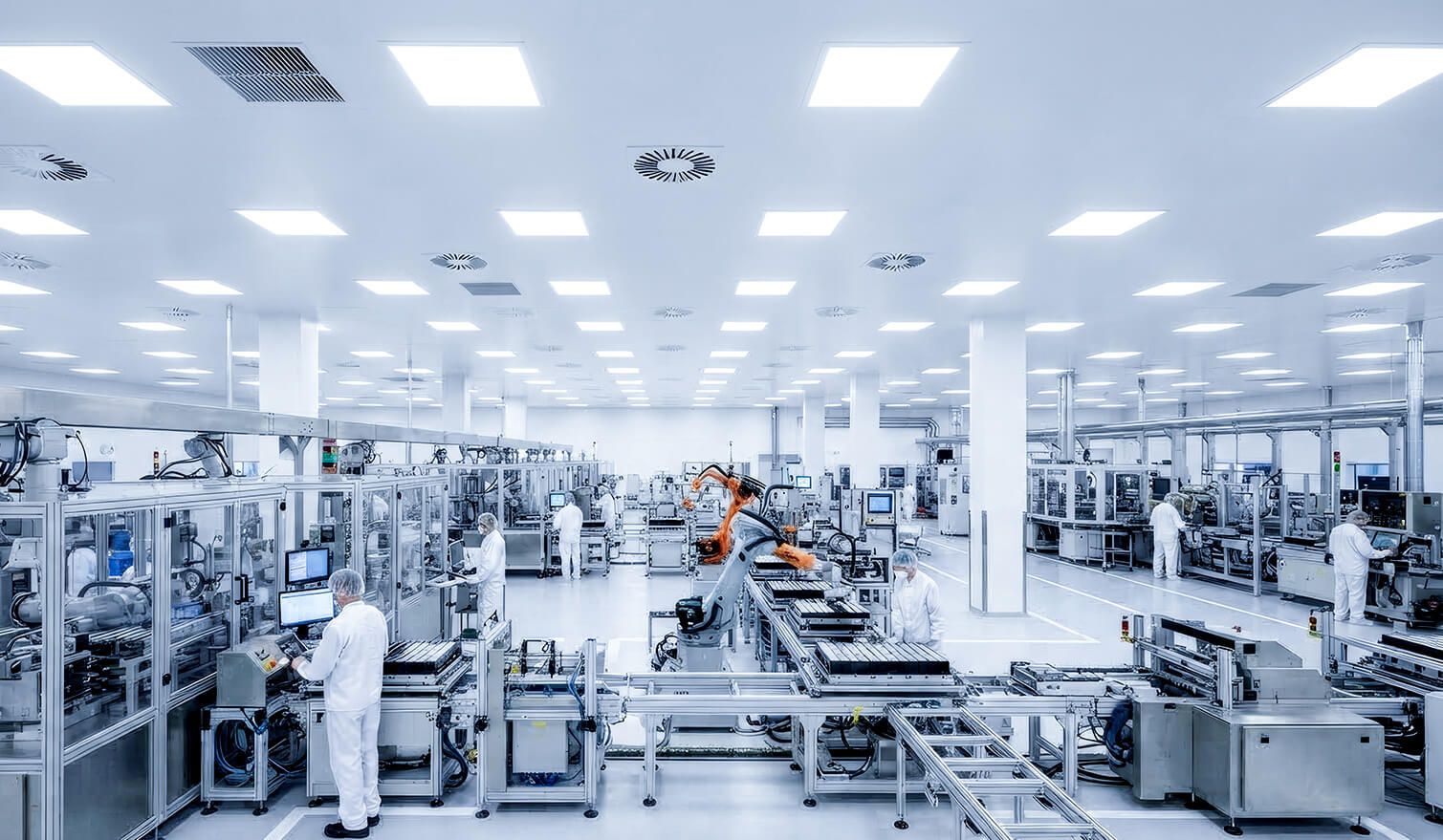 Das Innere einer Automobilfabrik mit Mitarbeitern an den Maschinen, wo eine angemessene Beleuchtung die Arbeitsqualität und -sicherheit fördert