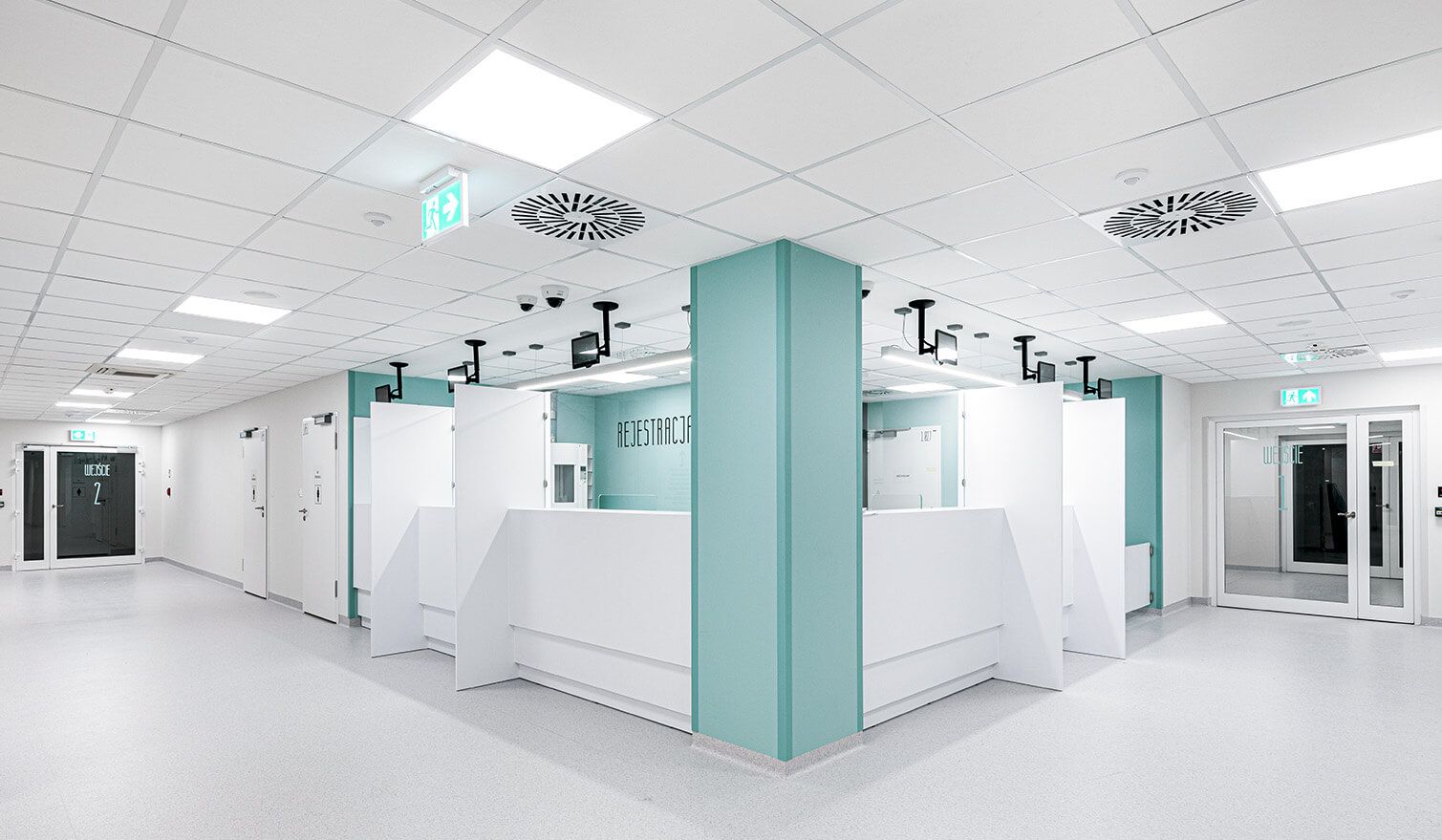 Ein Krankenhausflur mit weißer Decke und blauen Wänden, der eine freundliche und sichere Umgebung für die Patienten schafft. | Lumedic