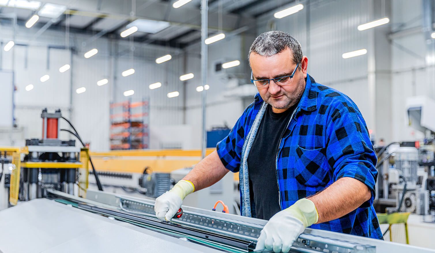  Ein Mann, der an einer Maschine in einer Fabrik arbeitet und sich auf die präzise Montage elektronischer Bauteile konzentriert