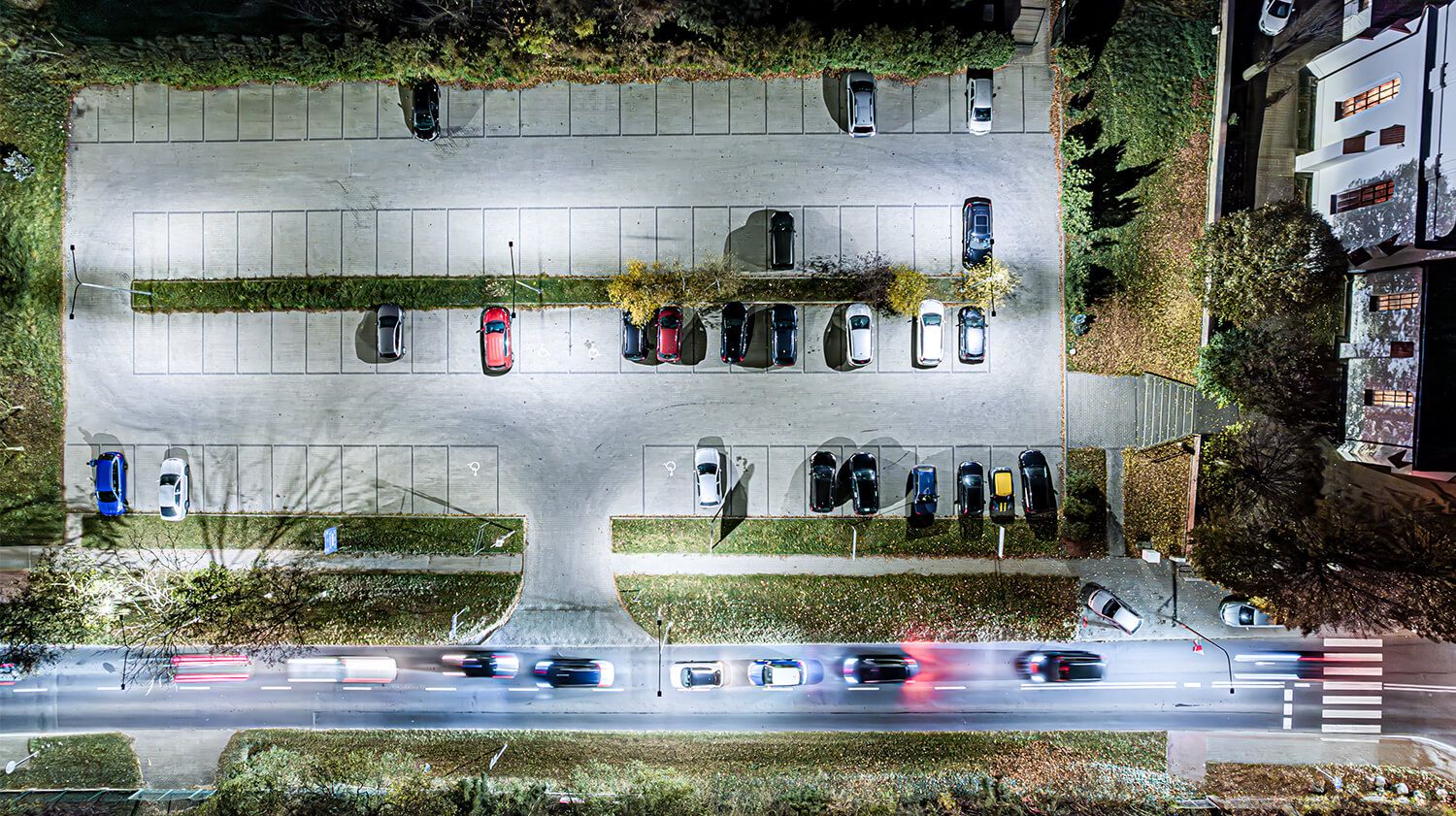  Blick auf einen Parkplatz mit Fahrzeugen, der die Bedeutung der Leuchten für die Sicherheit und Funktionalität unterstreicht.